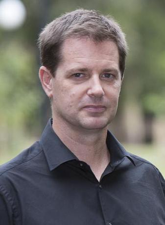 Should-up photo of Chris Gibson wearing a black collared shirt 