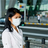 Woman at an airport wearing a protective mask from disease 