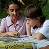 Two young children reading the newspaper 
