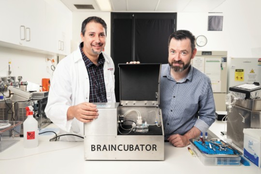 Two researchers with BrainWaves machine