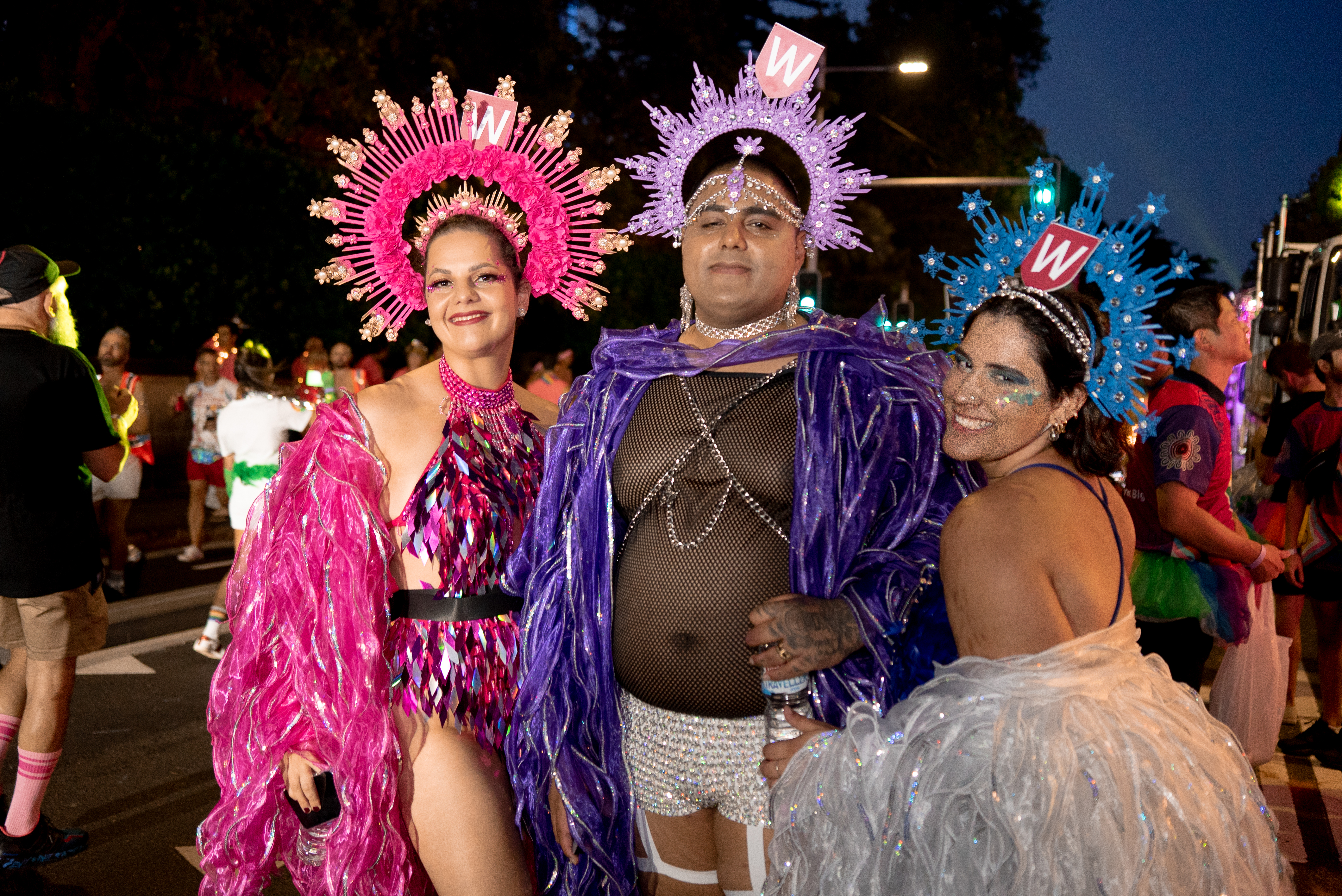 Three WSU Mardi Gras participants wearing extravagant costumes