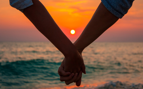 Holding hands at sunset