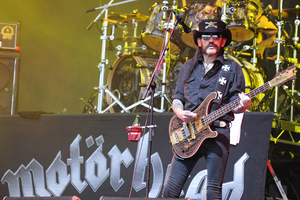 Rocker Lemmy standing with an electric guitar before a microphone