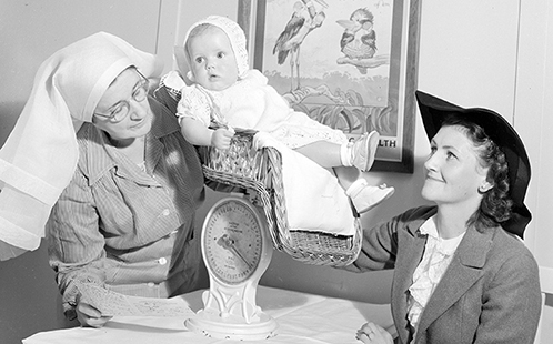 A nurse weighs a baby in Glen Innes, New South Wales, 1948.