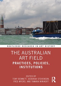 Cover of a book titled ‘The Australian Art Field’. On the top half of the cover is a photograph of Richard Bell’s sculptural protest ‘…no tin shack…’ on a barge in the Venice lagoon. Below the photograph is a thin white band with the words ‘Routledge Research in Art History’. The book title appears on the bottom half of the cover against a reddish background. It is ‘The Australian Art Field’. The subtitle is ‘Practices, Policies, Institutions’. Below the book title are the worlds ‘Edited by Tony Bennett, Deborah Stevenson, Fred Myers, and Tamara Winikoff’. The Routledge logo is in the lower right-hand corner of the cover.