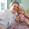 young Nurse and senior woman cuddling in a care home
