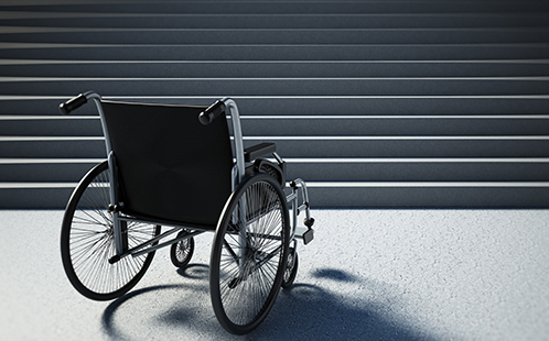 An empty wheelchair facing a staircase.